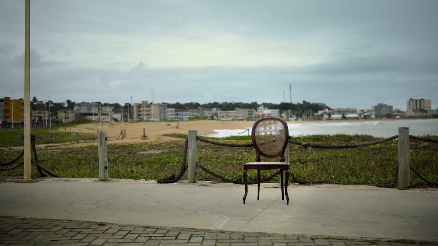 Uma cadeira sozinha na orla, de frente para a praia de Marataízes